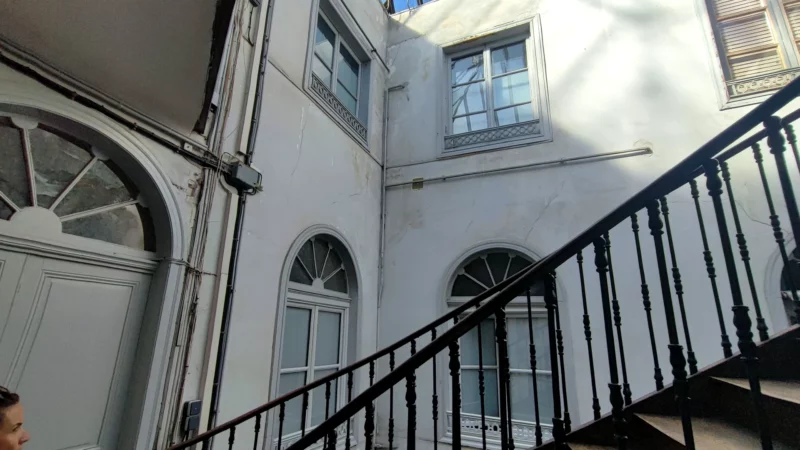 Cage d'escalier ancienne ouverte sur une cour intérieure couverte par une verrière.