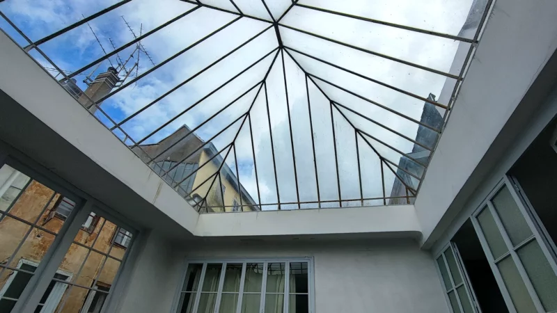 Structure métallique de la verrière observée depuis la cour intérieure de l'immeuble.