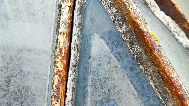 Détail d'un assemblage métallique corrodé au sommet de la verrière.