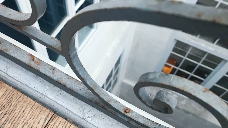 Détail de corrosion sur le garde-corps métallique de l'escalier intérieur.
