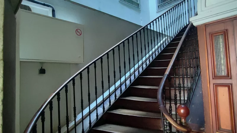 Escalier en bois avec rampe métallique à l'entrée de l'immeuble rue Port-Neuf.