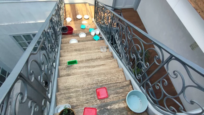 Escalier en bois avec garde-corps en fer forgé dans la cour intérieure de l'immeuble.