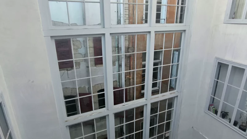 Grande façade vitrée donnant sur la cage d'escalier intérieure couverte de l'immeuble Lormand.