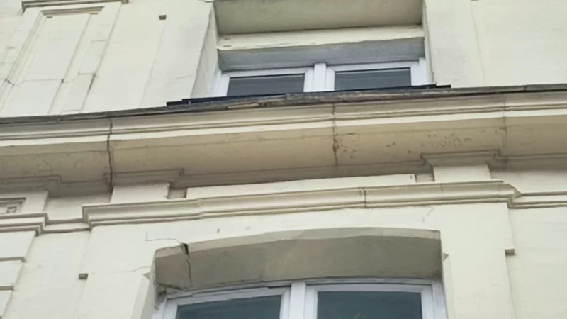 Fissuration des bandeaux et encadrements de fenêtres sur une façade ancienne.