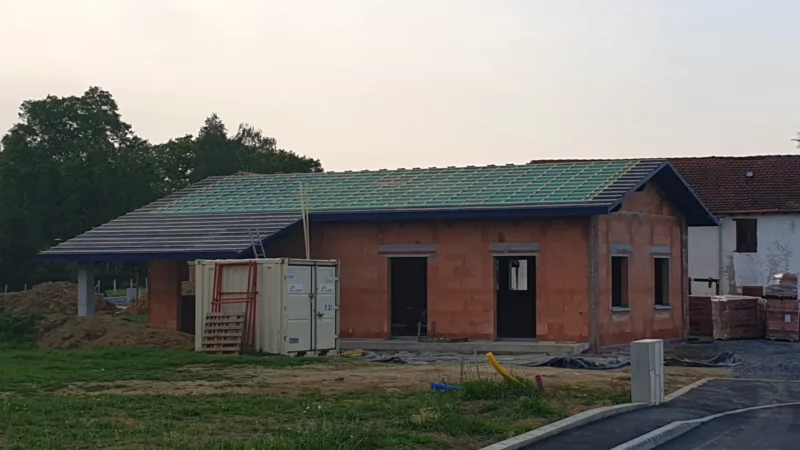Façade d’une maison neuve avec écran sous-toiture et liteaux en cours de pose.