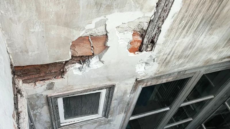 Pans de bois et maçonnerie apparents dans un mur dégradé de cour intérieure.