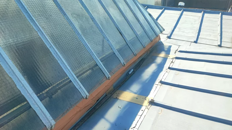 Raccord entre une verrière pyramidale et une couverture en zinc.