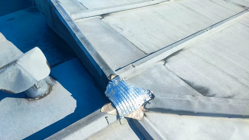 Réparation provisoire au croisement de plusieurs relevés d'une couverture en zinc.
