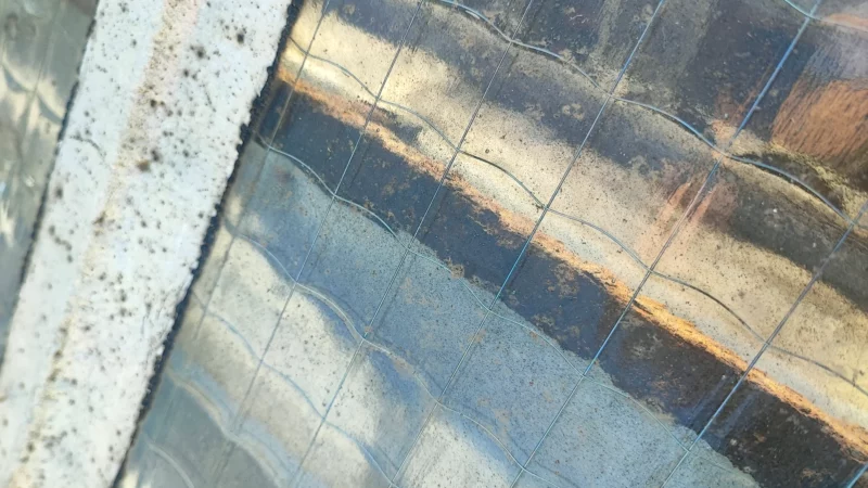 Détail du quadrillage et des salissures d'un vitrage armé de verrière.